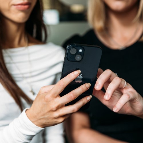 Reviewing a company social media content plan on a phone and laptop