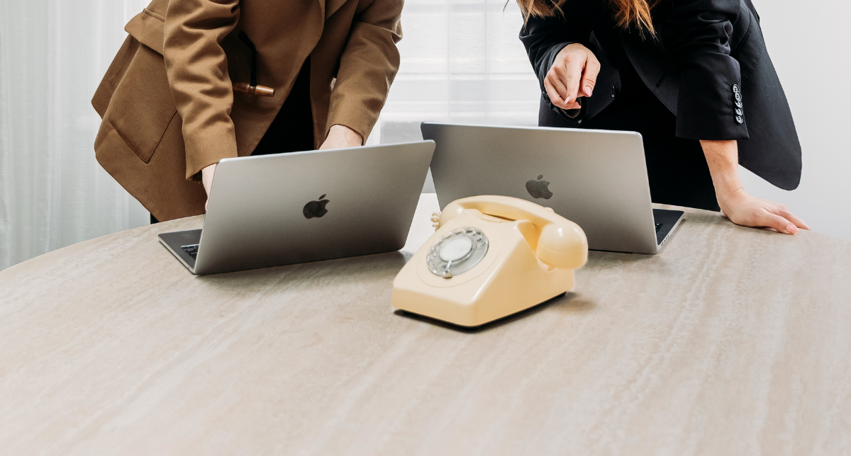 Two professionals working together around a laptop